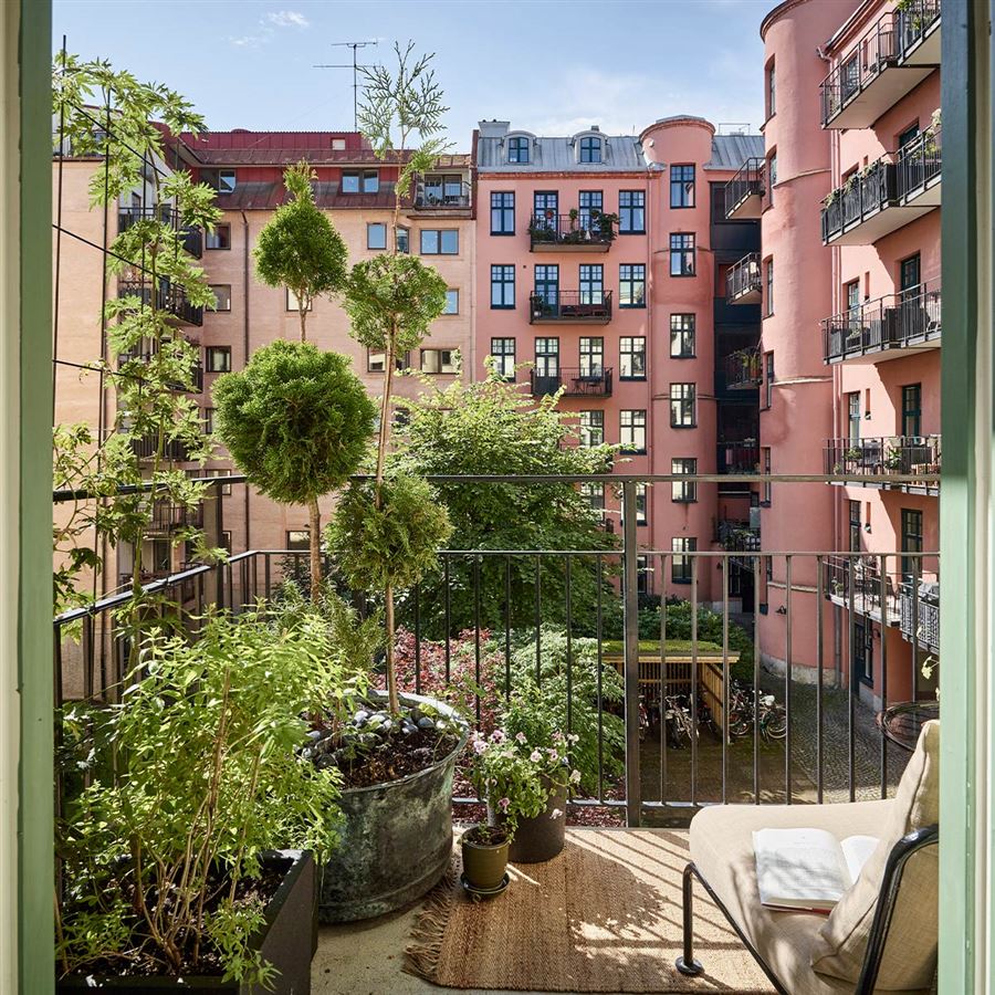 En balkong som vätter mot en grönskande innergård.