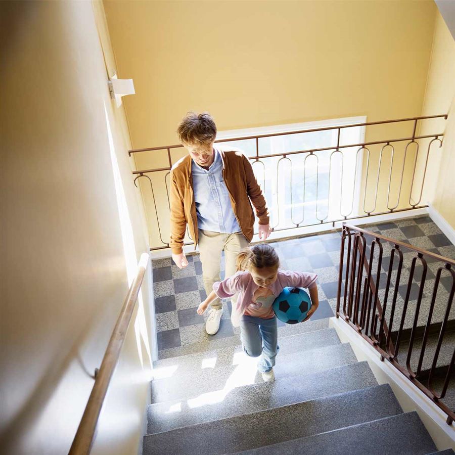 En pappa med sin dotter går i en trappa