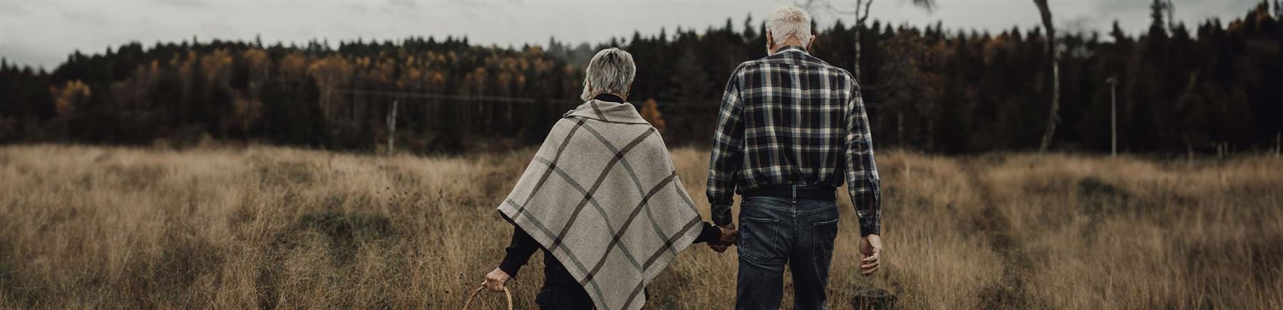 Ett äldre par promenerar i naturen